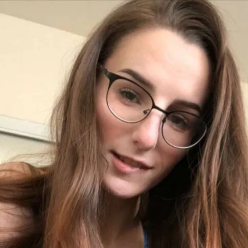 Jeune femme brune à lunettes se pince les lèvres