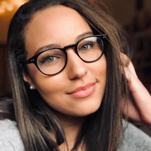 Jolie femme brune au yeux bleus avec des lunettes noires