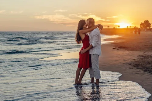 Deux amoureux s'embrasse au bord de la mer après une rencontre sur JM Date